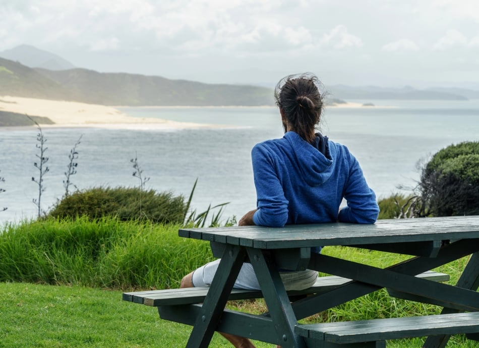 Back view of young man looking out to sea in NZ 