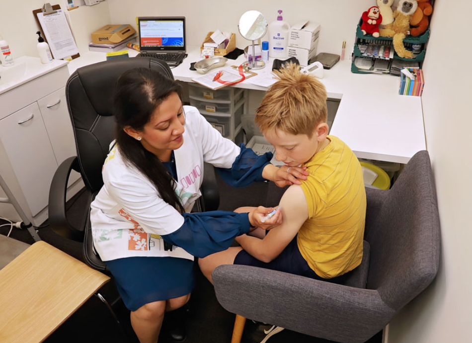 Young boy receiving vaccination in consultation room