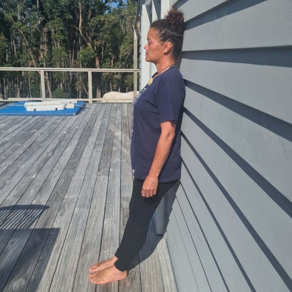 Woman standing and leaning back with wall for support