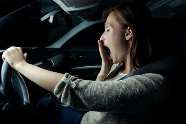 Woman yawning while driving at night