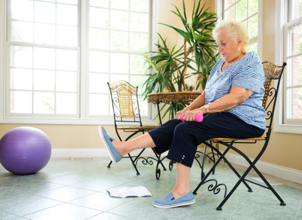 Older woman doing strengthening exercises while seated 