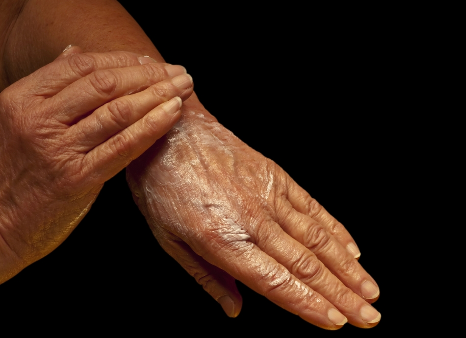 Older woman rubbing moisturiser into her hands 