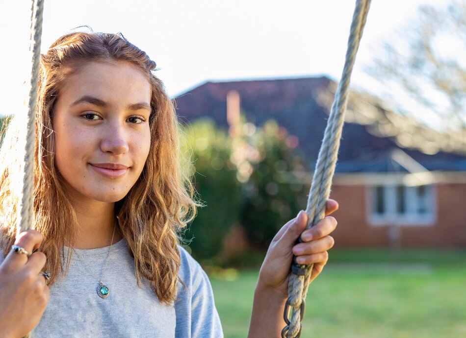 Teenage wahine Māori woman sits on swing