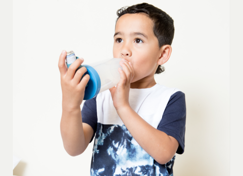 Boy using inhaler with spacer