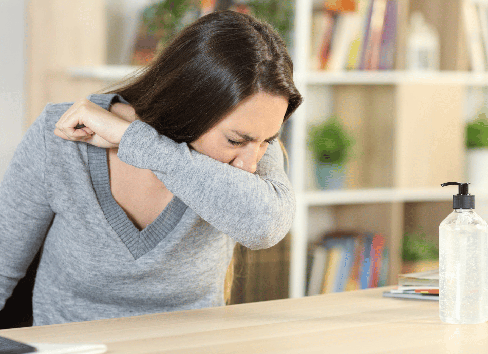 woman coughing into elbow